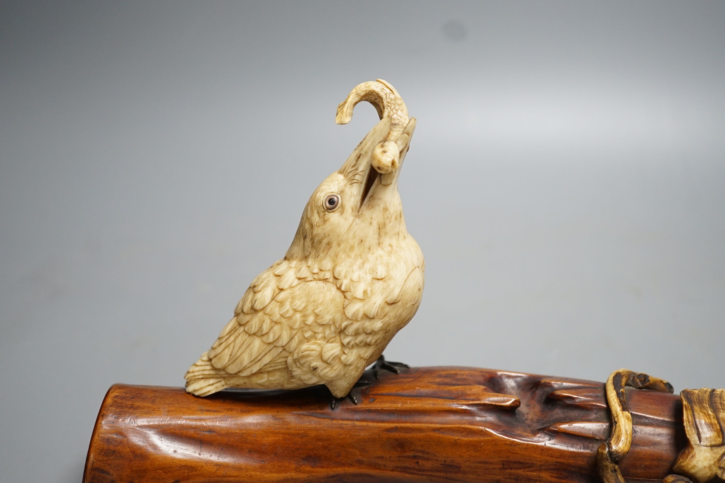 A 19th century Japanese ivory okimono of a kingfisher and log, mother of pearl inset eyes, signed to underside (a.f) 25cm long